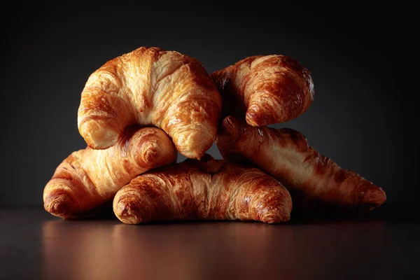 Freshly baked croissants on a black ceramic table. Traditional French kitchen.