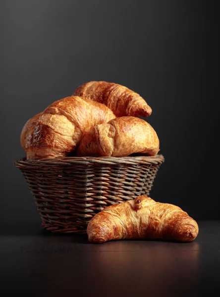 Fresh croissants on a black ceramic table. Traditional French kitchen. Copy space.