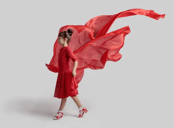 踊りの女の子で赤いドレスに赤い生地を飛んで — ストック写真