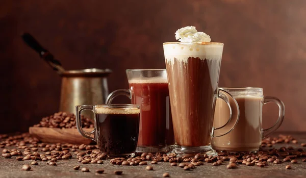 Verschiedene Kaffee Und Schokoladengetränke Mit Verstreuten Kaffeebohnen Auf Braunem Hintergrund — Stockfoto