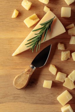 Parmesan cheese with rosemary on a wooden background. Top view.