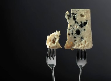 Blue cheese slices on a black background. 