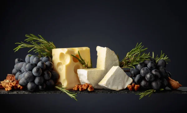 クルミ ブルーブドウ ローズマリーをダークな背景にしたチーズ スペースのコピー — ストック写真