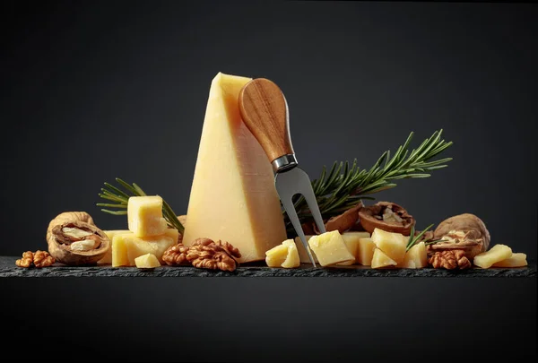 黒の背景にフォーク ローズマリー クルミのあるパルメザンチーズ — ストック写真