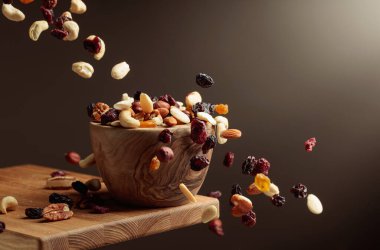 Uçan kurutulmuş meyve ve fındık. Fındık ve kuru böğürtlen karışımı ahşap bir kasede.. 