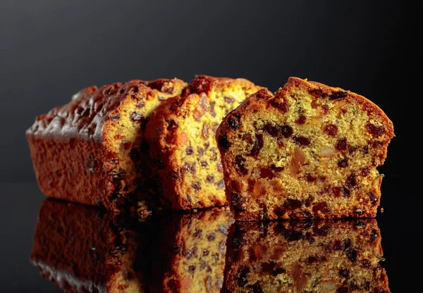 Kuchen Mit Rosinen Und Kandierten Früchten Auf Schwarzem Reflektierendem Hintergrund — Stockfoto