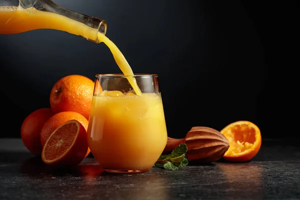 Pouring Orange Juice Bottle Glass Ice Black Background Copy Space — Stock Photo, Image