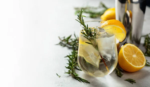 冷たいガラスの中で 天然の氷 レモン ローズマリーでリフレッシュドリンク 白い大理石のテーブルの上にジンと強壮カクテル スペースのコピー — ストック写真