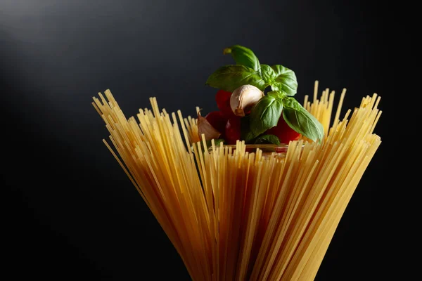 Espaguetis Crudos Con Tomate Ajo Albahaca Sobre Fondo Negro —  Fotos de Stock