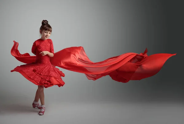 穿着红色连衣裙穿着飘逸的红色缎子织物跳舞的女孩 复制空间 — 图库照片