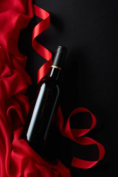 Bottle Red Wine Red Satin Black Background Top View — Stock Photo, Image