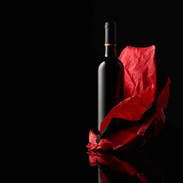 砕いた紙の上に赤ワインのボトル コピースペース付き黒の背景 — ストック写真