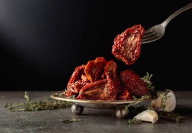 Taş bir masada güneşte kurutulmuş zeytinyağında domatesler. Boşluğu kopyala.