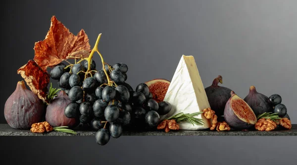 带有无花果 核桃和蓝色葡萄的奶酪边沿的深色背景 复制空间 — 图库照片