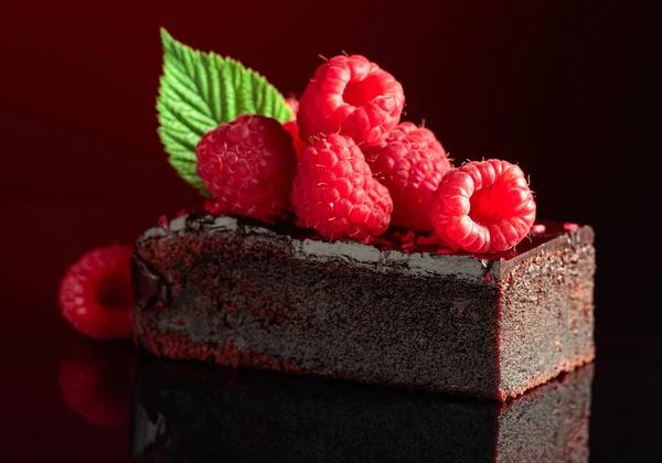 Pastel Chocolate Adornado Con Frambuesas Frescas Sobre Fondo Rojo Oscuro — Foto de Stock