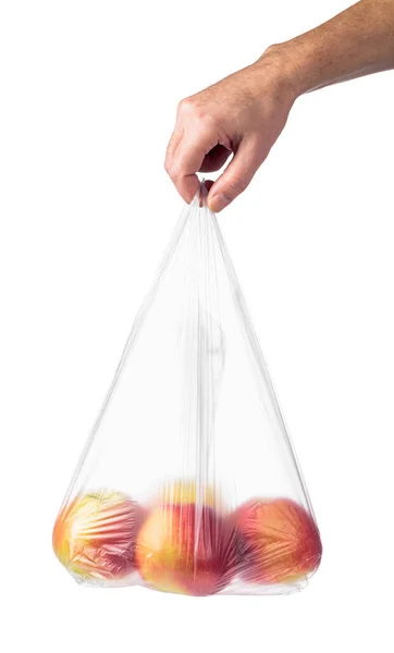 赤いリンゴの入ったビニール袋を手に持った男の手 白い背景に隔離された — ストック写真