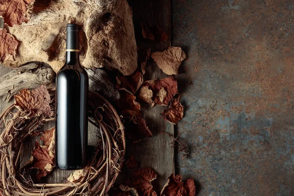 古い木と乾燥ブドウの葉とヴィンテージ素朴な背景に赤ワインのボトル 古いワインの概念 スペースのコピー — ストック写真