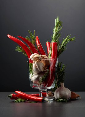 Kırmızı kırmızı biber, sarımsak ve biberiye siyah arka planda. Boşluğu kopyala..