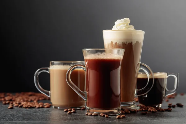 Разнообразные Кофе Шоколадные Напитки Разбросанными Кофейными Зернами Черном Столе — стоковое фото