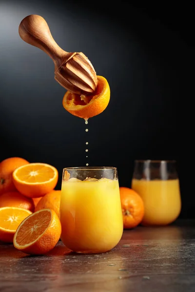 オレンジジュースは新鮮な果物から絞り出されます ジュースは氷でガラスに注がれます 自然有機食品の概念 — ストック写真