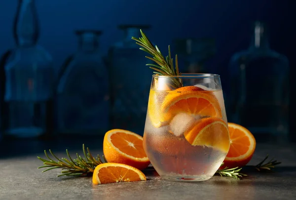 鸡尾酒杜松子酒汤加冰 迷迭香和橙子在酒吧的石桌上 — 图库照片