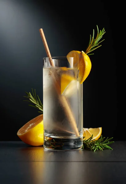 用鸡尾酒杜松子酒和补品在黑色背景上的冰冻玻璃杯 柠檬和迷迭香的清凉饮料 — 图库照片