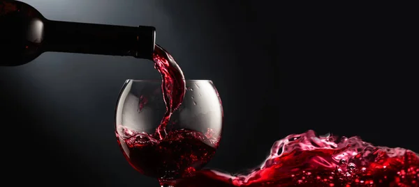Rode Wijn Een Wijnglas Gieten Een Zwarte Achtergrond Kopieerruimte — Stockfoto
