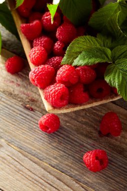 Eski ahşap arka planda yaprakları olan taze ahududular..