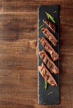 Eski ahşap bir masada ızgara biftek ve biberiye. Üst Manzara. Boşluğu kopyala.