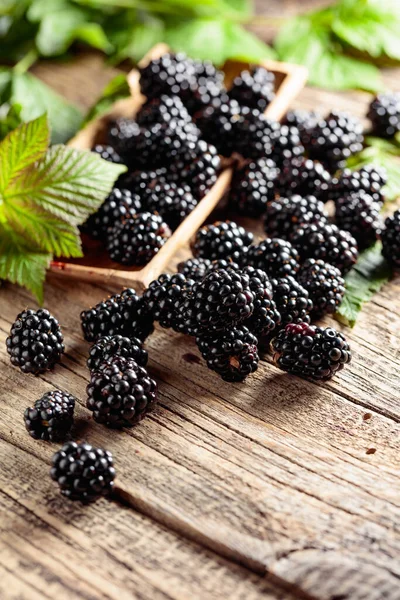 stock image Fresh blackberries with leaves on a old wooden table.