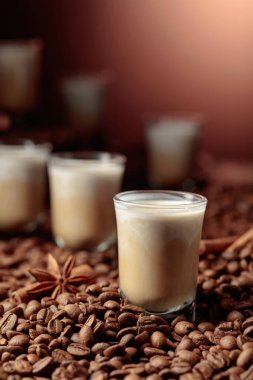 İrlanda kreması ve kahve likörü. Kahve çekirdekleri, tarçın ve anason masaya saçılmış. Boşluğu kopyala.