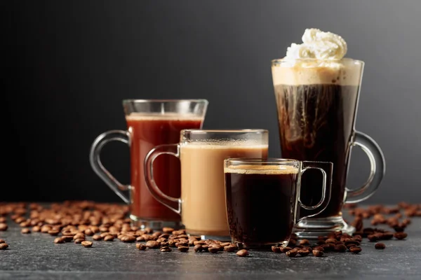 Kahve Çikolatalı Çeşitli Içecekler Siyah Bir Masanın Üzerinde Dağınık Kahve — Stok fotoğraf