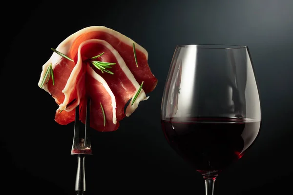 Glass Red Wine Sliced Prosciutto Rosemary Fork Black Background — Stock Photo, Image