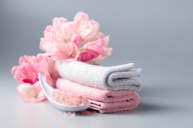 Pembe Himalaya tuzu, çiçeği ve havlusuyla spa kompozisyonu.