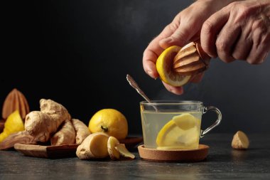 Limonlu ve ballı zencefil çayı. Meyve suyu eski bir tahta sıkacağıyla limondan sıkılır. Boşluğu kopyala.