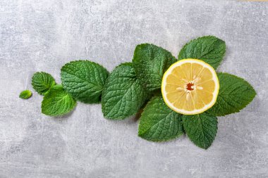 Lemon slice and mint leaves, top view.