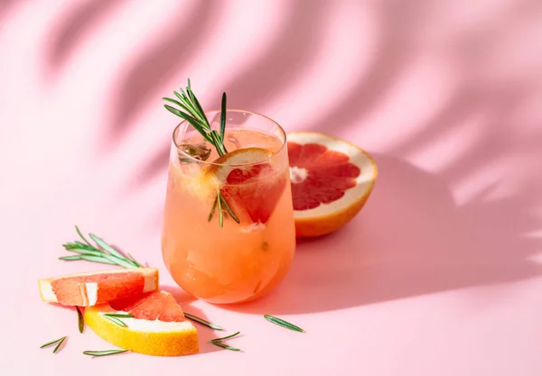 Summer Cocktail Grapefruit Rosemary Ice Drink Pink Background Palm Leaf — стоковое фото