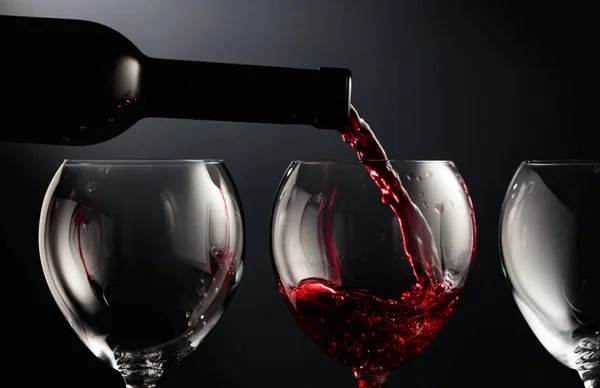 Despeje Vinho Tinto Copo Vinho Fundo Preto — Fotografia de Stock