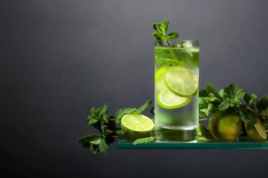 Buzlu, limonlu ve naneli mojito. Siyah arka planda sisli bardakta buzlu içecek. Boşluğu kopyala. 