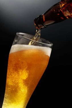 Şişeden büyük bir bardağa bira dolduruyorum..