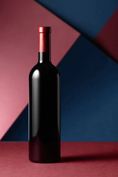 Una Botella Vino Tinto Sobre Fondo Rojo Azul Copiar Espacio —  Fotos de Stock