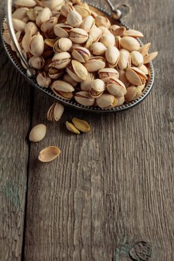 Eski ahşap bir masada tuzlu şam fıstığı.