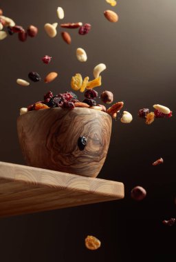 Uçan kurutulmuş meyve ve fındık. Fındık ve kuru böğürtlen karışımı ahşap bir kasede.. 