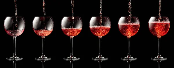 Despejando Vinho Rosa Copo Fundo Reflexivo Preto — Fotografia de Stock