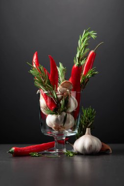 Kırmızı kırmızı biber, sarımsak ve biberiye siyah arka planda. Boşluğu kopyala..