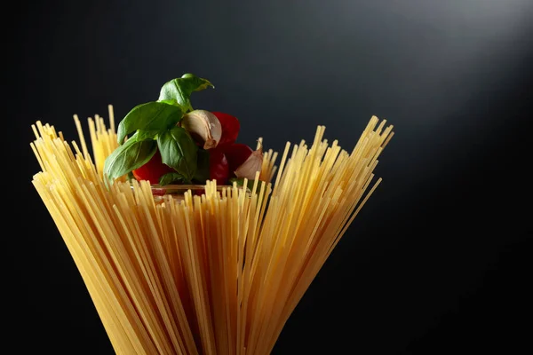 Rauwe Spaghetti Met Tomaat Knoflook Basilicum Een Zwarte Achtergrond — Stockfoto