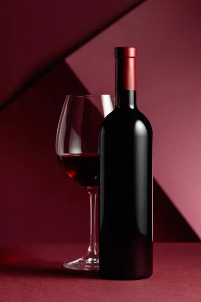 Μπουκάλι Και Ένα Ποτήρι Κόκκινο Κρασί Κόκκινο Φόντο Αντιγραφή Χώρου — Φωτογραφία Αρχείου