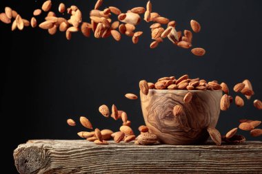 Badem ahşap bir kaseye dökülür. Kopyalama alanı ile ön görünüm.