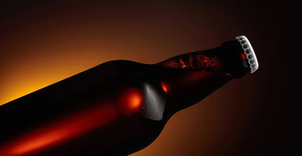 Nahaufnahme Einer Ungeöffneten Bierflasche Orange Hintergrundbeleuchtung — Stockfoto