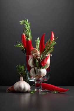 Kırmızı kırmızı biber, sarımsak ve biberiye siyah arka planda. Boşluğu kopyala..